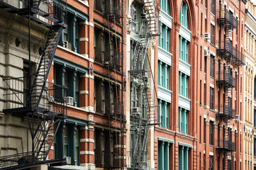 Close-up view of New York City style apartment buildings with emergency stairs along Mott Street in Chinatown neighborhood of Manhattan, New York, United States.