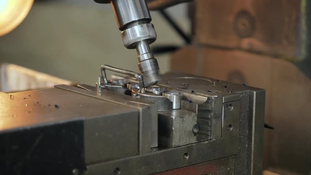 Drilling steel, slow motion. The boring machine processes metal, cuts a form.