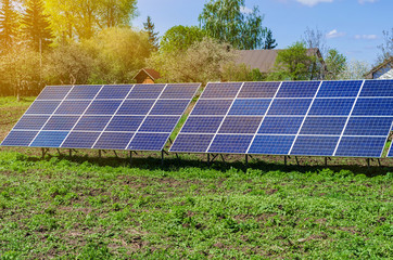 Photovoltaic ecological modules on green grass valley against of sun and cloudy sky