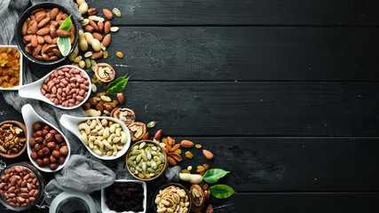 Assorted nuts on the old black background. Top view. Free space for your text.
