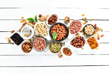 Assorted nuts on a white wooden background. Top view. Free space for your text.