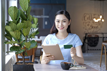 Asian pretty attractive woman sitting in coffee shop using smart phone