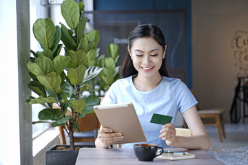 Asian pretty attractive woman sitting in coffee shop using smart phone