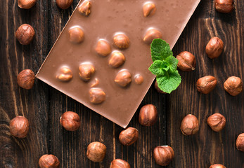 Chocolate pieces with nuts on wooden background