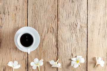 white coffee cup and frangipani flowers on old wooden table background