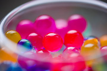 In the glass staan are round colored candies.