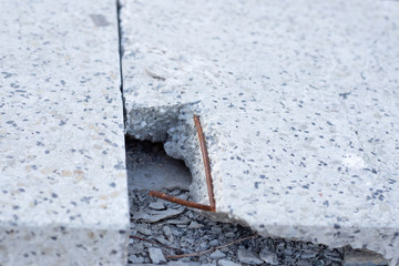 light grey cement slab with broken edges and reinforcement