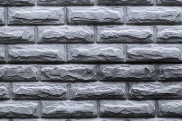 Gray brick fence. Fence made of artificial bricks. Gray brick wall texture