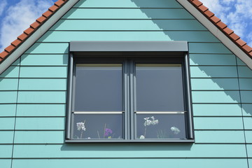 Fototapeta premium Blau gestrichene Holzplanken-Verschalung des isolierten und als Wohnung ausgebauten Dachgeschosses eines renovierten Fachwerkhauses