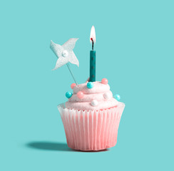 Celebratory cupcake with a decorative lit candle