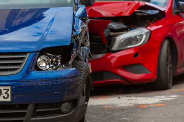 Close-up of two deformed Cars - red and blue - after a Car Crash, Collision, Accicent