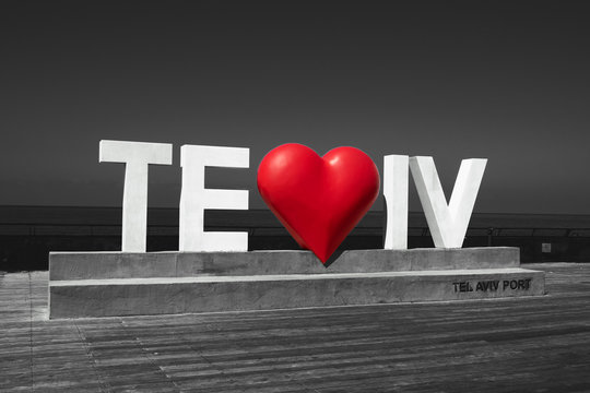 Tel Aviv love sign with heart at city port. Tel Aviv (Israel) port is a popular recreational and commercial area for locals and tourists. Black white red retro toned photo.