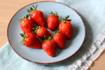 Strawberries on a rustic turquoise plate. Selective focus.
