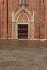 Entrance Door to a Church made of red Brickstone in Venice, Italy, on a rainy Winter Day