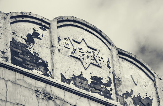 Old weathered building with Star of David and hebrew date 5689 written in hebrew letters corresponding to Gregorian calendar 1929 year. Tel Aviv, Israel. Black white photo.