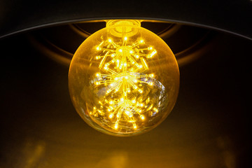 Close up incandescent lamp shining, Yellow light of lamp hang on ceiling
