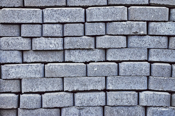 Fragment of the gray textured paving slab laying in long parallel non-even lines as a background close-up.