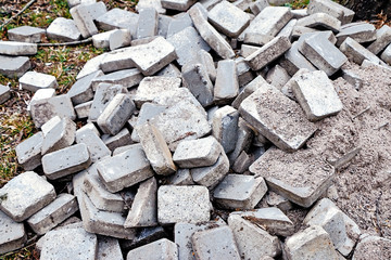 Old paving slabs are piled on the ground in the park.