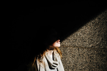 beautiful girl in coat with scarf walks on city street, portrait of woman resting outdoors