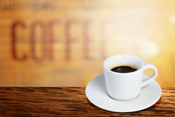 Coffee cup on wooden table on blurred of interior coffee shop. Business time with coffee, Coffee color brown background for product display, free copy space. Industrial food, drink background concept.