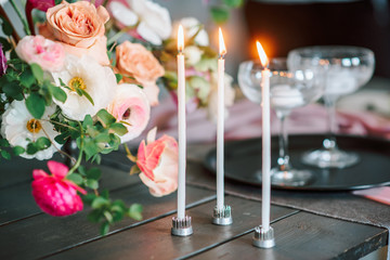 Laying and decor of the wedding banquet table. Plates, knives, forks, glasses, plates, flowers, snacks and fruit. The main thing in the details.