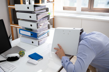 Businessman Hiding Under Folder