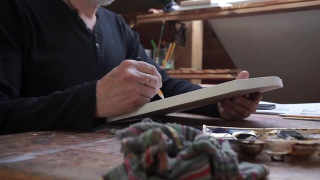 man, drawing a sketch in his studio