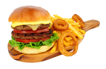Cheese beef burger and French fries with battered onion rings on an olive wood serving board...