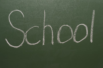 Handwritten inscription in chalk school on a green blackboard.