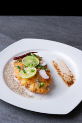 Spicy salad with fried chicken in white dish on table.