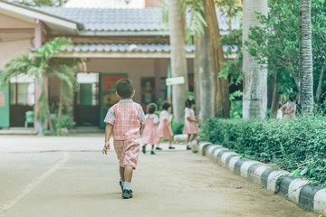 Fototapeta na wymiar Back view of Boy followed girl friends on street to go to the classroom in school.