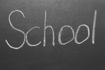 Handwritten inscription in chalk school on a gray board.