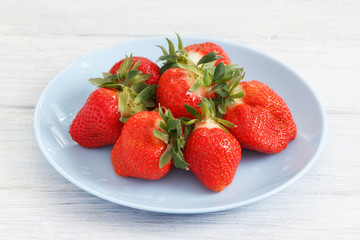 Fresh red sweet strawberry on blue plate