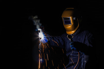 Working person About welder steel Using electric welding machine There are lines of light coming out and safety equipment.