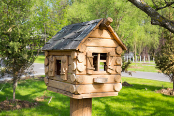 House of wooden bars with Windows as a bird feeder.