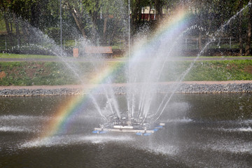 Fountain with a rainbow in the city Park.
