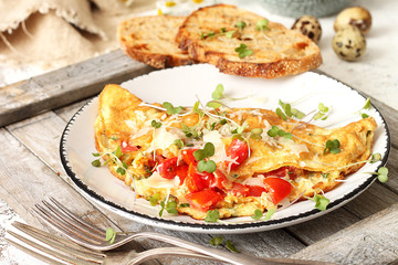 Homemade breakfast omelette with tomatoes, cheese and herbs