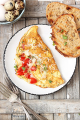 Homemade breakfast omelette with tomatoes, cheese and herbs