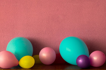 Multicolored balloons on a pink background. Empty space for your text