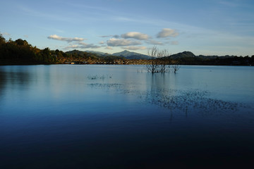 Landscape of Uttamanusorn Bridge or Mon Bridge and river and blue sky in the evening at Sangkhlaburi district, Kanchanaburi province, Thailand.