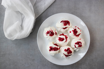 Meringues with whipped cream and raspberry sauce on a white plate. Dessert Pavlova.