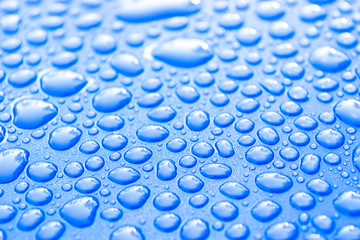 Transparent still water drops on light blue background. Blue water drops. Drops of rain on glass. Blue abstract water drop background. Water surface