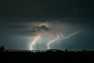 Fototapeta na wymiar Beautiful but dangerous lightning strikes in central Transylvania, Romania. Strong thunderstorms on an evening in the month of May in eastern Europe.