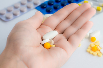  many pills in hand on white background