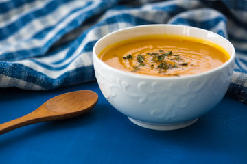 Pumpkin cream soup. Fresh soup with herbs on a background, Autumn concept. Tasty healthy food.
