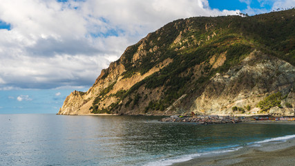Fototapeta na wymiar Stunning landscape of the beautiful Ligurian Sea and rugged sheer mountain cliffs of the Monterosso al Mare village, in Cinque Terre, Italy.