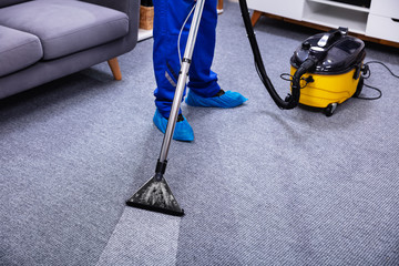 Person Cleaning Carpet With Vacuum Cleaner