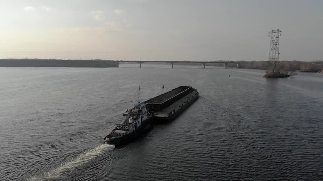 Tugboat pushes barge on the river, Ukraine Dnieper, aerial view