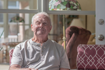 Portrait of a man in his late seventies enjoying the morning in his home.