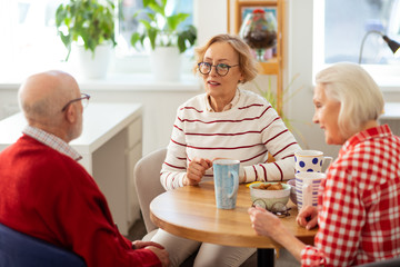 Pleasant aged people having delicious tea together